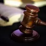 Ex-lawmaker can remain judge in COVID-19 benefits case, cour