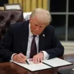 trump at desk signing things
