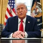 Trump sitting at oval office desk