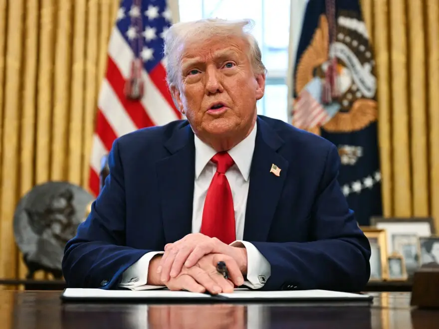 Trump sitting at oval office desk
